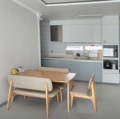 a kitchen with a wooden table and two chairs at Moon and 7 Pence in Iksan