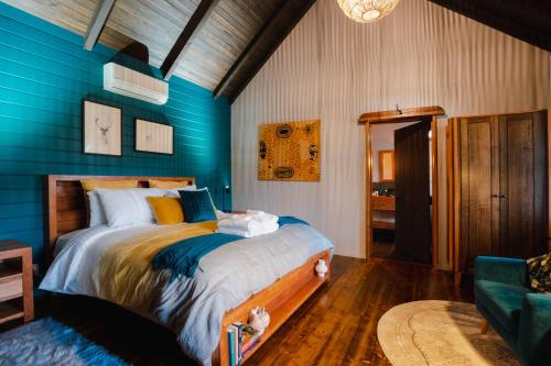 a bedroom with blue walls and a large bed at Eliza's in Bright