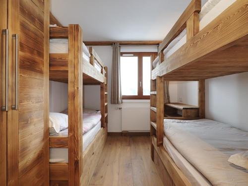 two bunk beds in a room with wooden walls at Appartement rénové 88m2 au centre de Courchevel 1850 - 8 pers, parking, balcon, WIFI - FR-1-631-146 in Courchevel