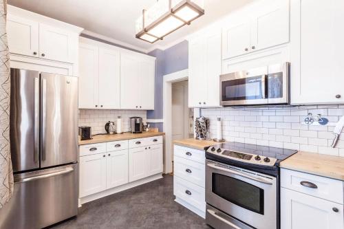 a kitchen with white cabinets and a stainless steel refrigerator at Renovated 3/2 * Craftsman Home * Perfect Location in Memphis