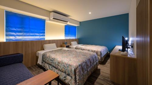 a hotel room with two beds and a television at Ise City Hotel in Ise