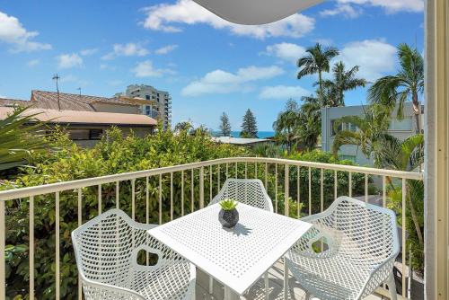 a white table and chairs on a balcony at Surf Dance Apartments in Coolum Beach
