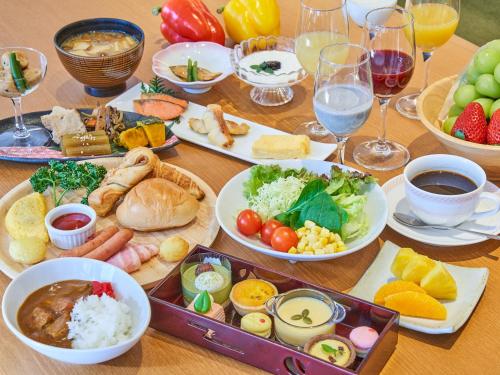 蔵王温泉にある蔵王四季のホテルの食べ物の皿とワインのグラスが置かれたテーブル