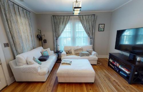 a living room with two white couches and a flat screen tv at Renovated 3/2 * Craftsman Home * Perfect Location in Memphis