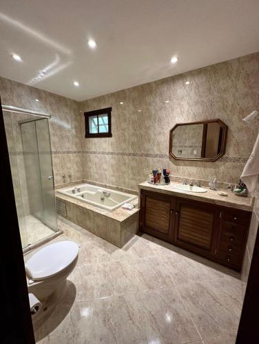 a bathroom with a tub and a toilet and a sink at Casa aconchego Secretário in Araras Petropolis