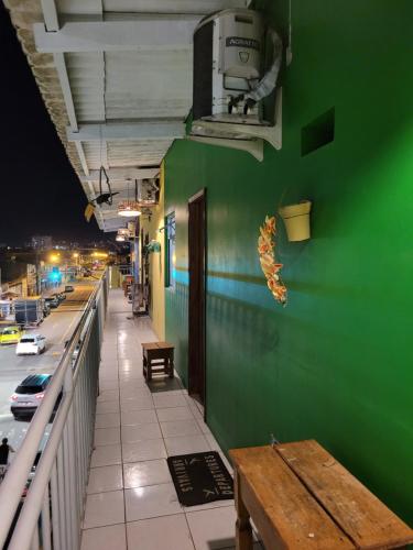 un mur vert avec un banc sur le côté d'un bâtiment dans l'établissement Namoasuites, à Maceió