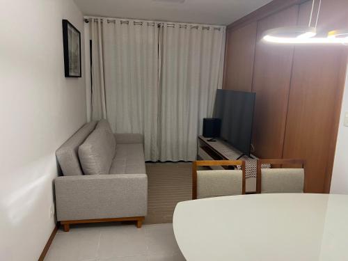 a living room with a chair and a television at Salvador Prime - Caminho das Árvores in Salvador