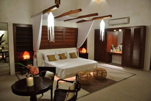 a bedroom with a bed and a table and chairs at Casa los Cocoteros in Gallinero