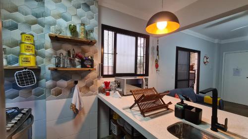 a kitchen with a sink and a counter top at Lazer Aconchegante na Guilhermina in Praia Grande