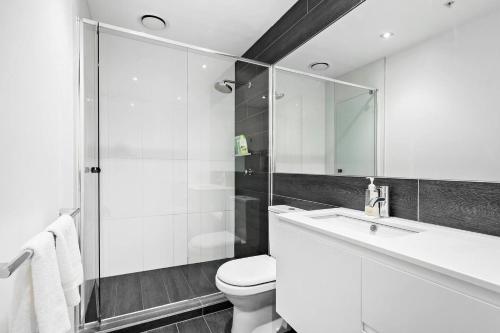 Un baño con inodoro y ducha de cristal. en Sunshine Place - Heart of St Kilda with Parking, en Melbourne