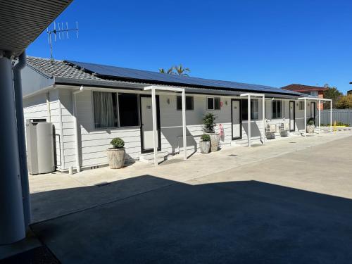 a white building with plants in front of it at Surf Beach Motel Port in Port Macquarie