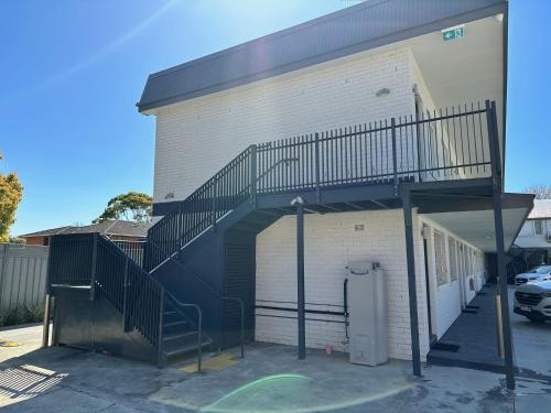 a garage with a staircase on the side of a building at Surf Beach Motel Port in Port Macquarie
