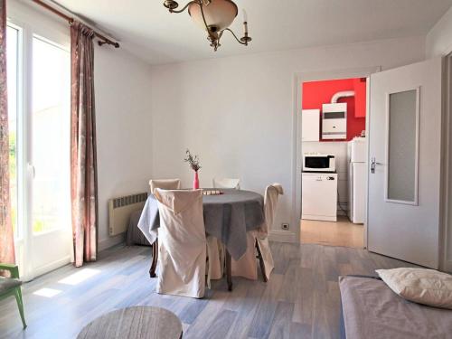 une salle à manger avec une table et une cuisine dans l'établissement Appartement lumineux pour famille à Royan, quartier calme près du marché, balcon et parking gratuit - FR-1-738-26, à Royan