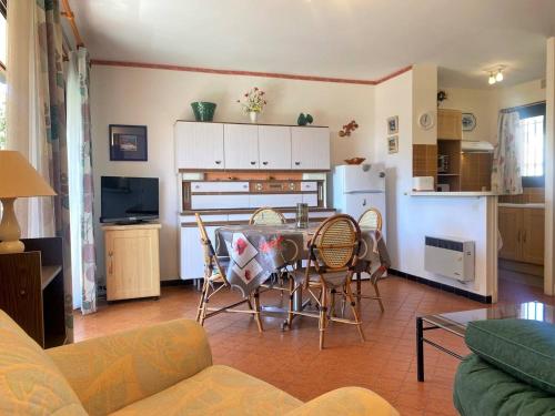 une cuisine et un salon avec une table et des chaises dans l'établissement Appartement calme, 4 couchages, proche plage et commerces, terrasse exposée sud, parking privatif - FR-1-251-508, au Lavandou