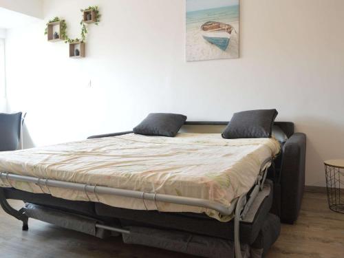 un lit avec deux oreillers dessus dans une chambre dans l'établissement Appartement Refait à Neuf, 5 Couchages, à 50m de la Plage, Parking Privé - Narbonne Plage - FR-1-229B-95, à Narbonne