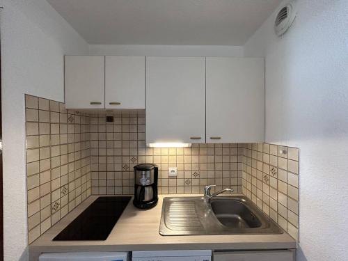 - une cuisine avec un évier et des placards blancs dans l'établissement Studio cabine, 4 pers, pied des pistes à Briançon, balcon, parking - FR-1-330C-140, à Briançon