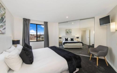 una habitación de hotel con una cama grande y una silla en Griffin Apartments Kingston ACT en Canberra