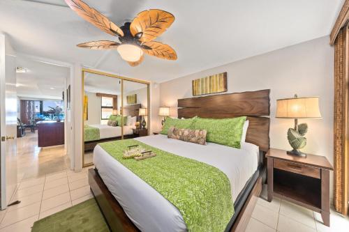 ein Schlafzimmer mit einem großen Bett mit einer grünen Bettdecke in der Unterkunft Kaleialoha 213 in Lahaina