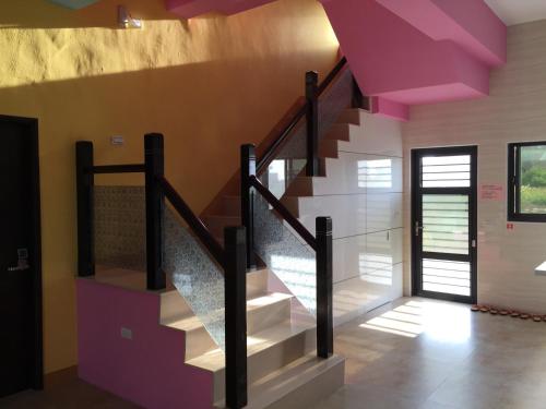 una escalera en una casa con techo púrpura en 日青民宿, en Magong