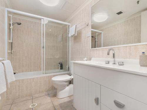 a bathroom with a toilet and a sink and a shower at Peninsula 21b in Gold Coast