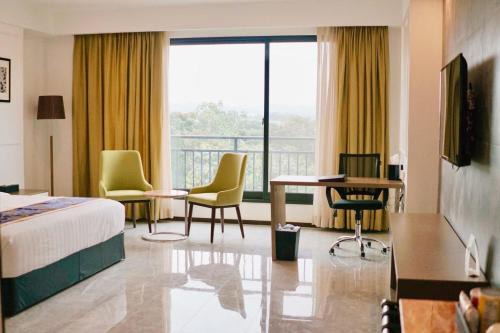 um quarto de hotel com uma cama, uma mesa e cadeiras em Hevea Hotel & Resort em Angeles