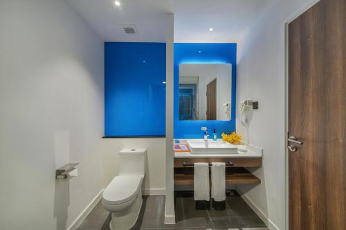 a bathroom with a toilet and a sink and a mirror at Holiday Inn Express Xiamen Airport Zone by IHG in Xiamen