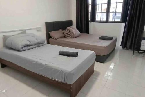 um quarto com 2 camas e um sofá em Diamond Bay Homestay em Teluk Intan