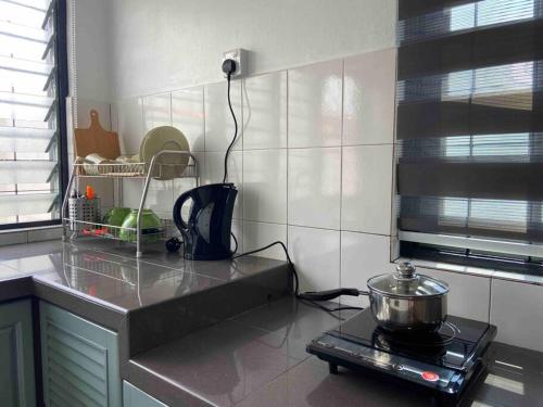a kitchen with a counter with a pot on a stove at Diamond Bay Homestay in Teluk Intan
