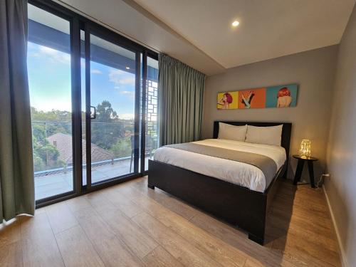 a bedroom with a bed and a large window at Studio 8 Residences - Adults Only in Sydney