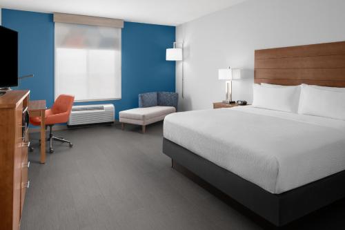 a hotel room with a bed and a desk and a chair at Holiday Inn Express & Suites Midland South I-20, an IHG Hotel in Midland