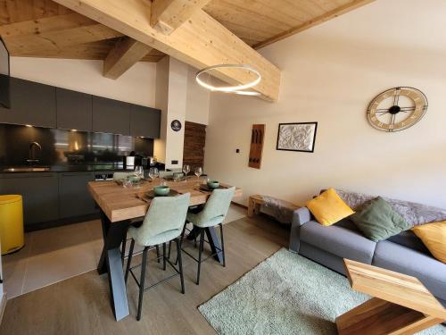 une cuisine et un salon avec une table et un canapé dans l'établissement Appartement 3★ pour 4 avec balcon, proche centre et pistes, Les Gets - FR-1-598-152, aux Gets