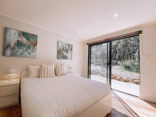 亚林加普Wren Studio - Private One-Bedroom Studio Nestled in Bushland的一间带床和大窗户的白色卧室