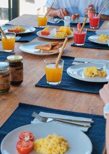 a table with plates of breakfast foods and drinks at DUNIA LOMBOK - Villas with Ocean View in Selong Belanak