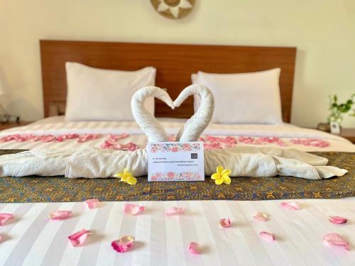 two swans made out of towels sitting on a bed at Grey House Monkey Forest in Ubud