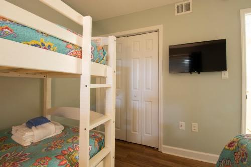 a bedroom with a bunk bed and a tv at Family Getaway - Boardwalk to the Beach, 3 pools, Tennis in Hilton Head Island