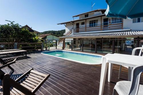 una terraza con piscina y una casa en Hospedagem Engenho Fortaleza, en Florianópolis