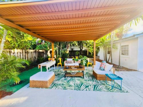 um pátio com uma pérgola de madeira com cadeiras e uma mesa em Miami Oasis: Private House, Backyard and BBQ em Miami