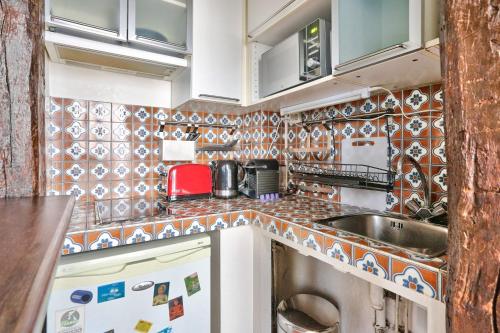 Il comprend une petite cuisine équipée d'un évier et d'un lave-vaisselle. dans l'établissement Studio Mezzanine Quartier Luxembourg Free Netflix, à Paris