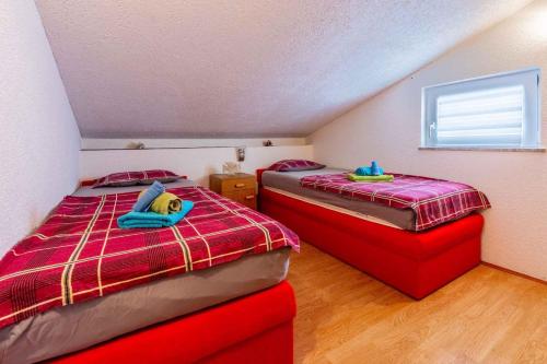 duas camas num quarto com lençóis vermelhos e azuis em Apartment in Novi Vinodolski 41901 em Novi Vinodolski