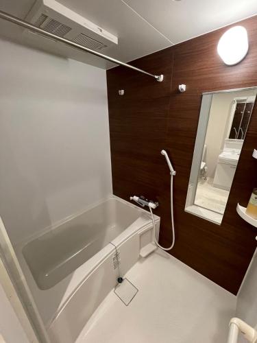 a bathroom with a bath tub and a mirror at The Grand Residence Hotel Tenjin in Fukuoka