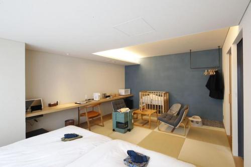 a bedroom with a bed and a desk and a crib at Matsumoto Jujo in Matsumoto