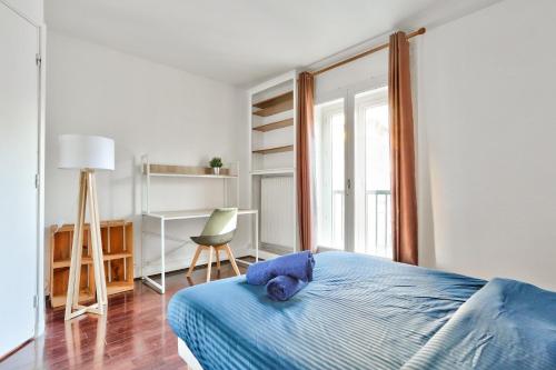 a bedroom with a blue bed and a chair at Appartement Quartier Saint Michel in Paris