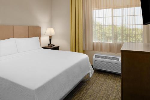Habitación de hotel con cama grande y ventana en Candlewood Suites Turlock, an IHG Hotel, en Turlock