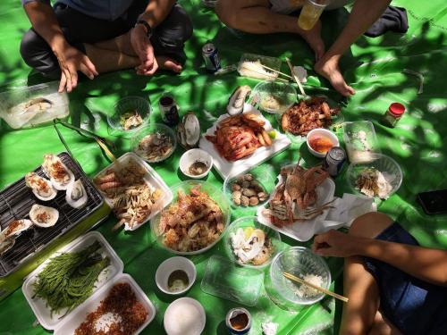 a group of people sitting around a table with food at Romny cozy bay Resort in Koh Rong Sanloem