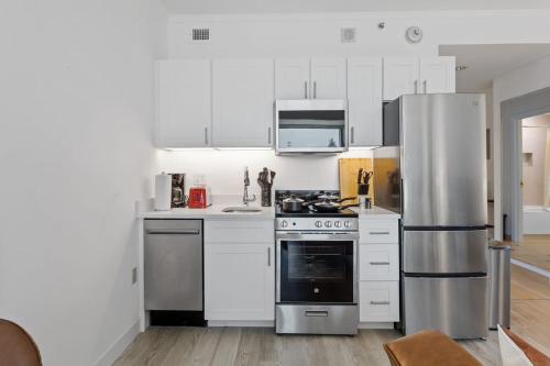 a kitchen with white cabinets and a stainless steel refrigerator at Boardwalk CozySuites Condo with kitchen 48 in Atlantic City
