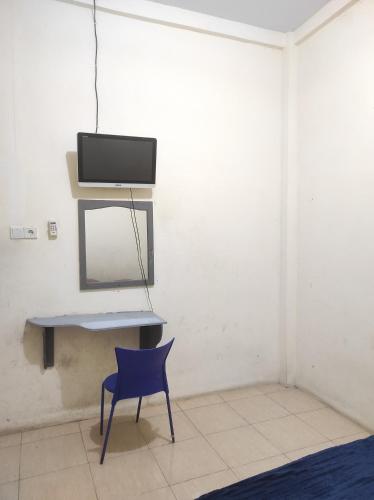 Topoyo的住宿－Wisma Tiga Putra Belawa 1，一张桌子,椅子和镜子在房间内