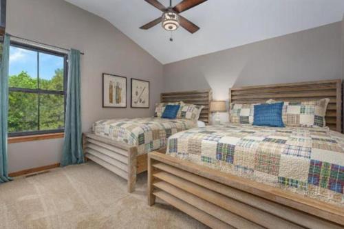 a bedroom with two beds and a ceiling fan at SPACIOUS HAPPY HOME in Branson with 8 BEDS & 6 BATHS in Hollister