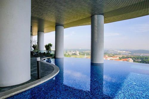 uitzicht op een zwembad met zuilen en water bij 2109 Encorp Marina Flex suite netflix By STAY in Nusajaya