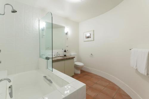 ein weißes Badezimmer mit Badewanne und Toilette in der Unterkunft No 3 @ The Hill Apartments in Port Douglas