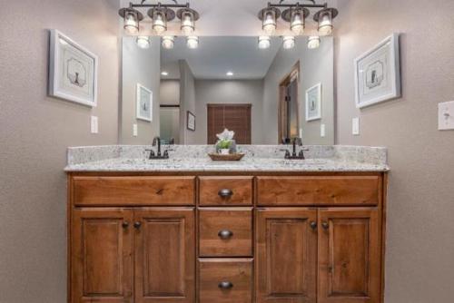 baño con 2 lavabos y espejo grande en SPACIOUS HAPPY HOME in Branson with 8 BEDS & 6 BATHS en Hollister